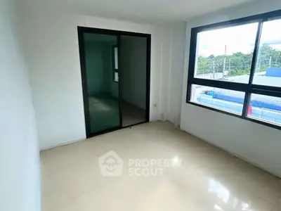 Bright empty room with large window and sliding glass door