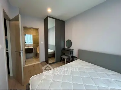 Modern bedroom with ensuite bathroom and stylish furniture in a cozy apartment.