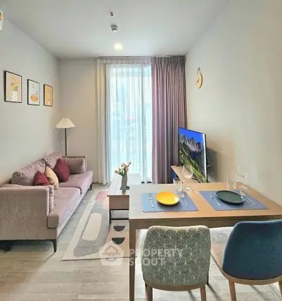 Modern living room with stylish decor, cozy sofa, dining table, and large window with curtains.