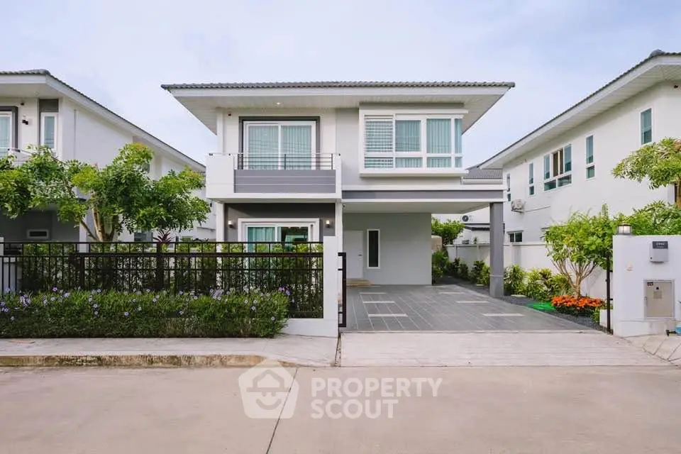 Modern two-story house with sleek design and landscaped garden in a serene neighborhood.