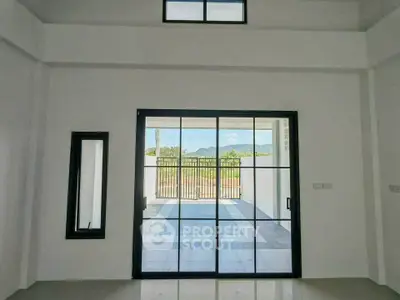 Spacious interior with large glass doors opening to a scenic view, perfect for modern living.