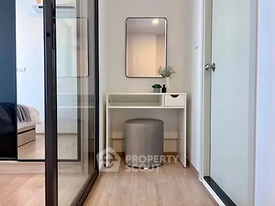 Modern apartment hallway with stylish vanity and mirror, featuring sleek design and natural light.