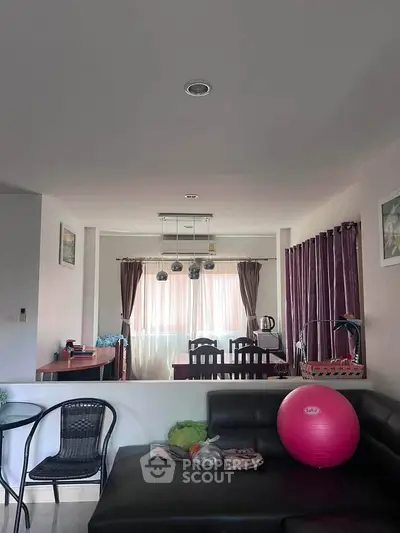 Spacious living room with modern decor and ample natural light, featuring a cozy seating area and elegant dining space.
