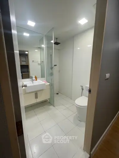 Modern bathroom with glass shower and sleek fixtures in a contemporary apartment.