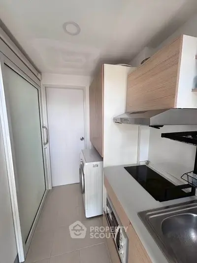 Modern kitchen with sleek cabinetry and built-in appliances in a compact layout.