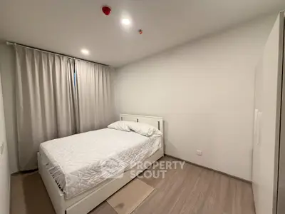 Modern minimalist bedroom with white bed and curtains, perfect for cozy living.
