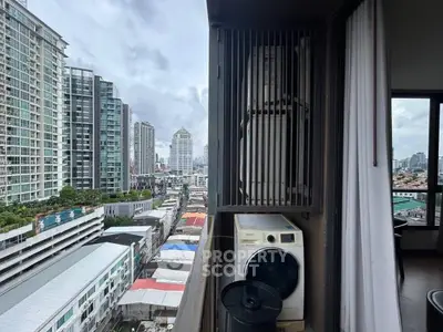 High-rise balcony with city view and laundry appliances, perfect urban living.