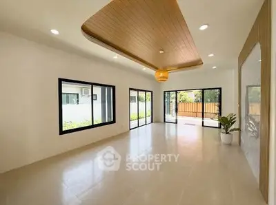Spacious modern living room with large windows and elegant ceiling design