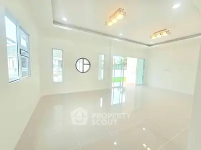 Spacious and bright living room with modern lighting and large windows.