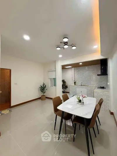 Modern dining area with elegant lighting and open kitchen layout