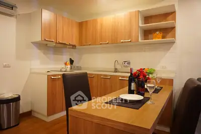 Modern kitchen with wooden cabinets and dining area in cozy apartment