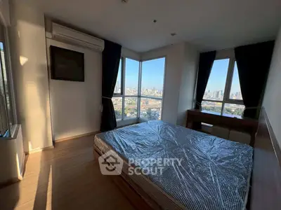 Modern bedroom with large windows offering stunning city views