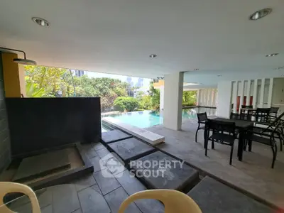 Luxurious poolside area with modern seating and city view, perfect for relaxation and entertainment.