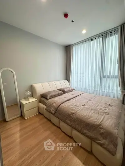 Modern bedroom with stylish bed and floor-to-ceiling windows in a cozy apartment.