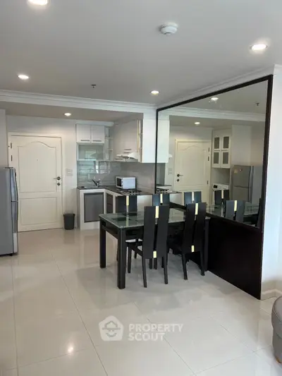 Modern open-layout kitchen and dining area with sleek furniture and appliances.