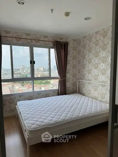 Cozy bedroom with large window offering stunning city views, featuring elegant wallpaper and a comfortable bed.