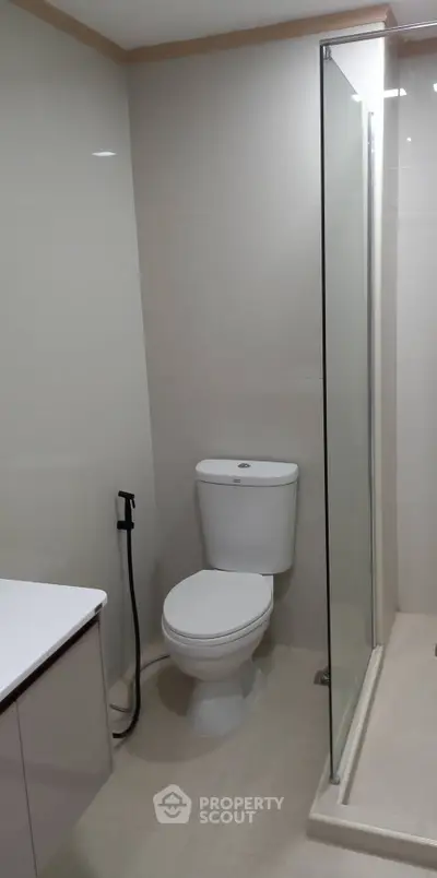 Modern bathroom with sleek design featuring a glass shower enclosure and contemporary fixtures.