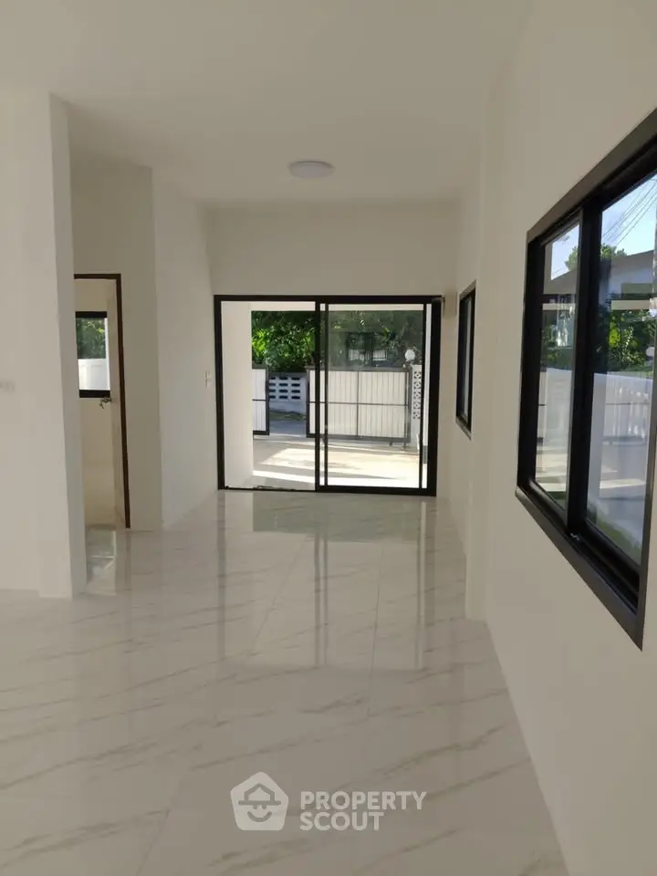 Spacious modern living room with large windows and marble flooring