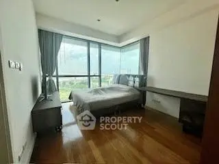 Spacious bedroom with large windows and wooden flooring