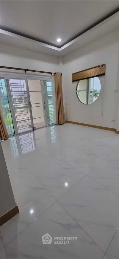 Spacious empty room with large windows and modern tile flooring