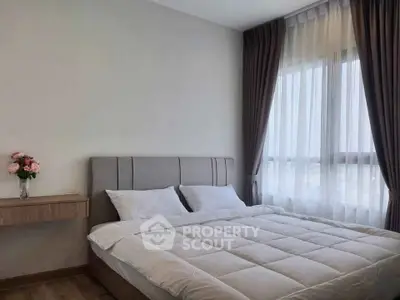 Elegant bedroom with large window and modern decor, perfect for relaxation and comfort.