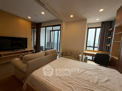 Modern studio apartment with cozy living area and city view balcony, perfect for urban living.
