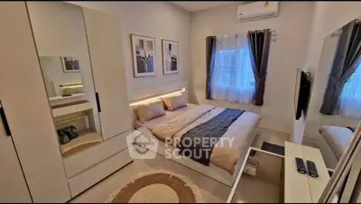 Modern bedroom with stylish decor, featuring a cozy bed, mirrored wardrobe, and ambient lighting.