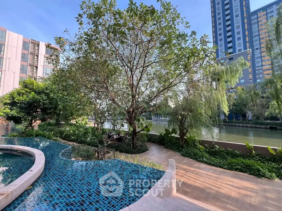 Luxurious riverside apartment with stunning pool and lush garden view