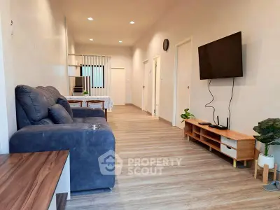 Spacious modern living room with sleek furniture and wall-mounted TV