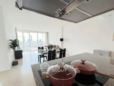 Modern open-layout kitchen with city view, featuring sleek countertops and dining area.
