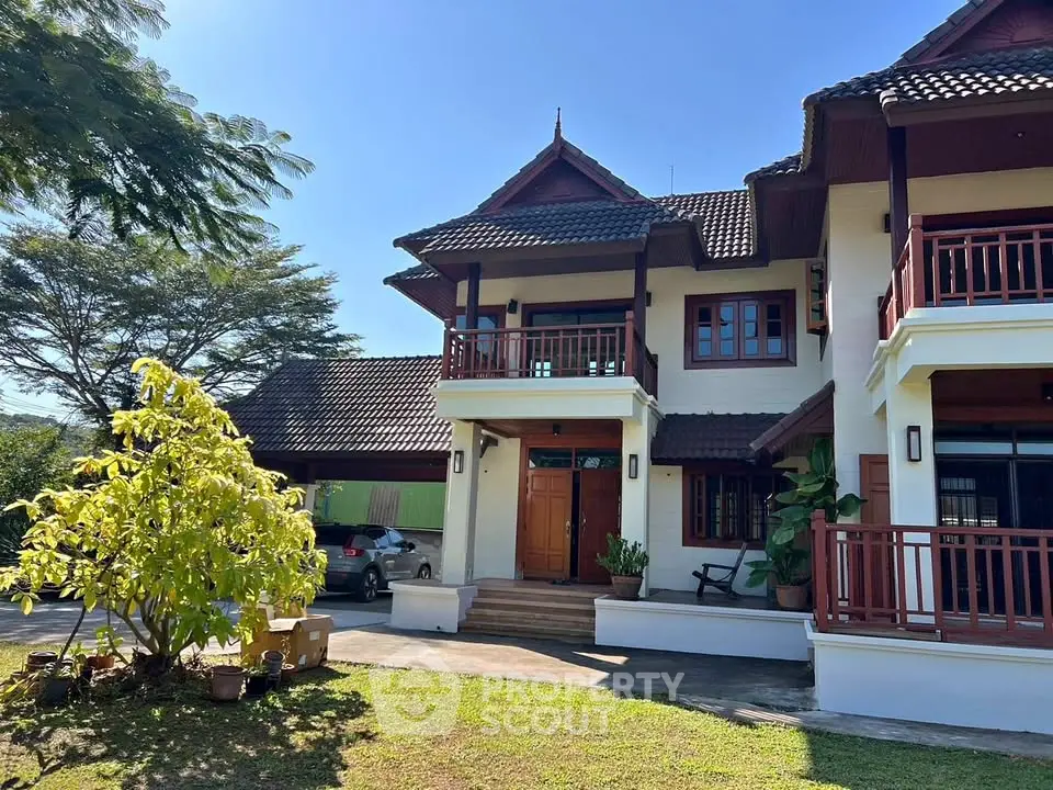 Charming two-story house with traditional architecture and lush garden, perfect for serene living.