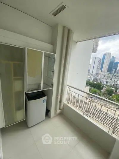 High-rise balcony with city view and washing machine, ideal for urban living.