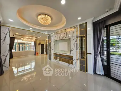 Luxurious living room with marble accents and elegant chandelier in modern home.