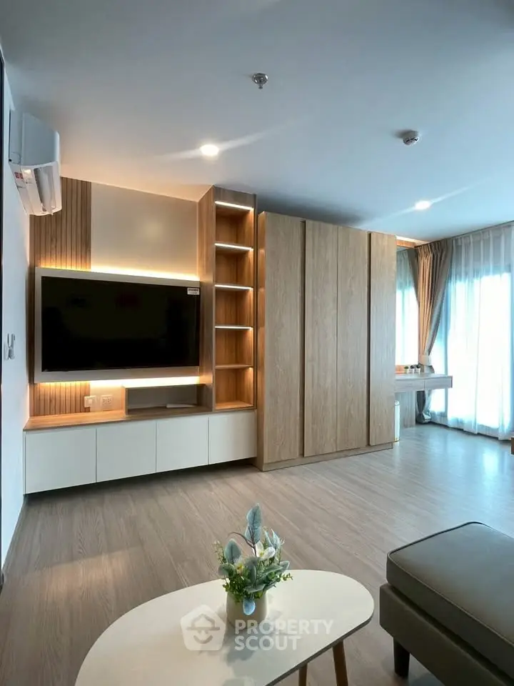 Modern living room with sleek wooden cabinetry and large windows for natural light.