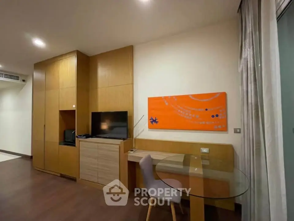 Modern living room with stylish furniture and vibrant artwork, featuring a cozy workspace and sleek design.