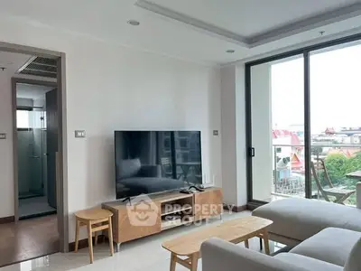 Modern living room with large TV and balcony view in a stylish apartment.