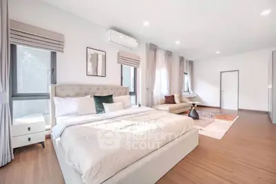 Spacious and bright bedroom with modern decor and large windows