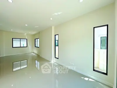 Spacious and bright empty room with large windows and glossy floor