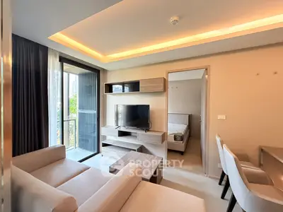 Modern living room with cozy sofa, TV, and access to a balcony in a stylish apartment.