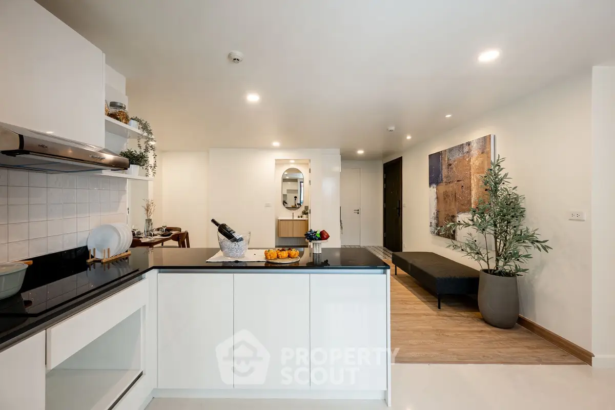 Modern open-layout kitchen with sleek design and stylish decor in a contemporary apartment.