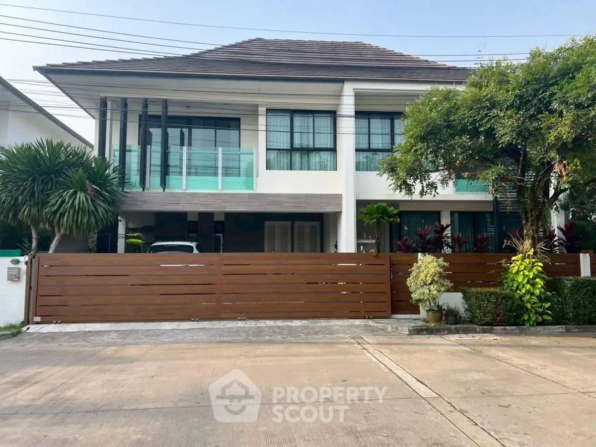 Stunning modern two-story house with sleek design and lush greenery, perfect for luxurious living.