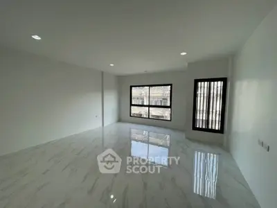 Spacious modern living room with large windows and marble flooring