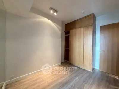 Spacious empty room with wooden flooring and built-in wardrobe, perfect for customization.