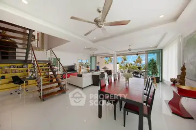 Spacious modern living room with open layout and stunning view, featuring elegant dining area and stylish staircase.
