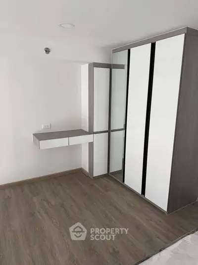 Modern bedroom with sleek wardrobe and wooden flooring
