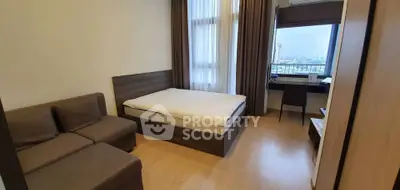 Modern bedroom with city view, featuring a cozy bed and stylish furniture.