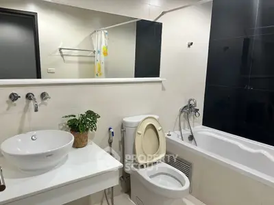 Modern bathroom with sleek fixtures and a bathtub in a stylish apartment.