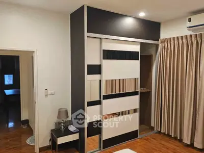 Modern bedroom with stylish wardrobe and wooden flooring