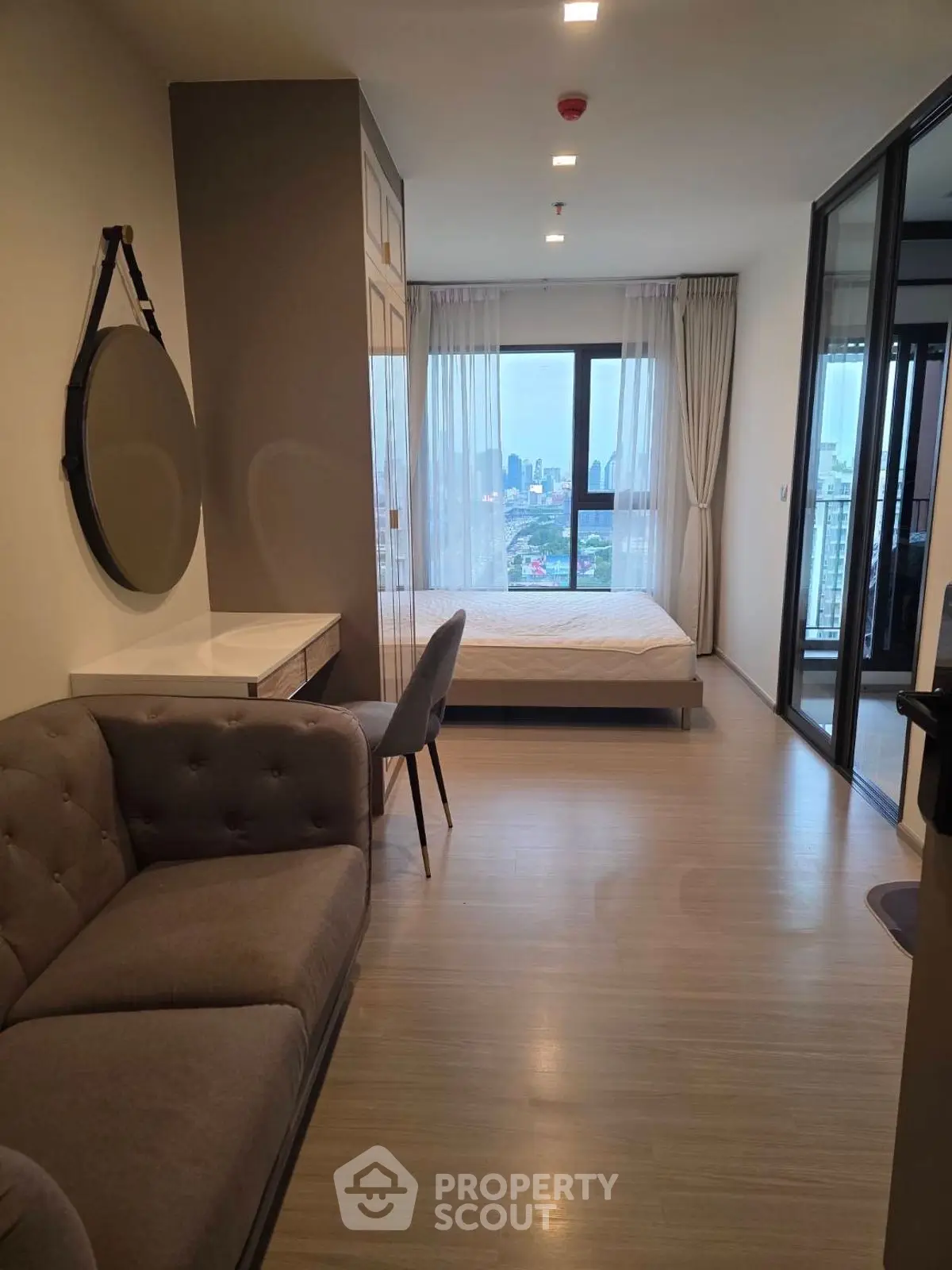 Modern studio apartment with city view, featuring cozy living area and stylish bedroom.