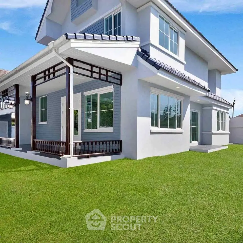 Stunning modern two-story house with lush green lawn and large windows.